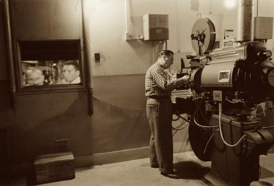 Man working with projector in movie theater 1958